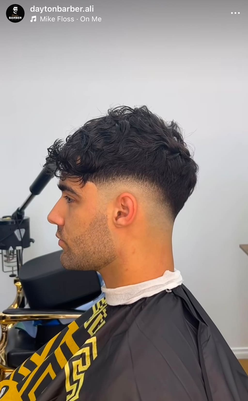 Curly top with a clean skin fade through the sides